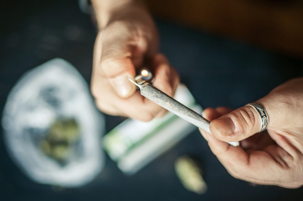 two hands lighting a joint