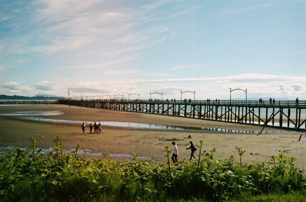 People walking along the beach of White Rock Pier, BC