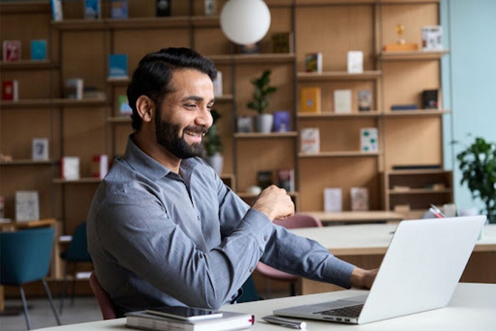 Smiling man using a laptop to shop online.